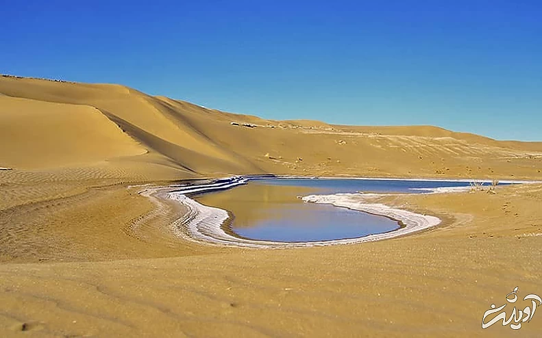 دریاچه ای در وسط منطقه ای کویری و کنار تپه ای شنی